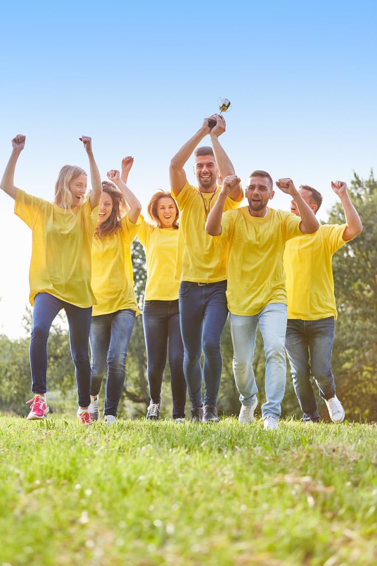 Winning Team with Cup Cheers at Team Building Event